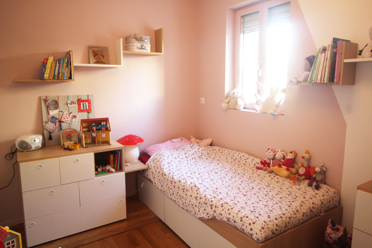 Réalisation de chambre d'enfant for fille With un mur rose, parquet clair and un sol marron.