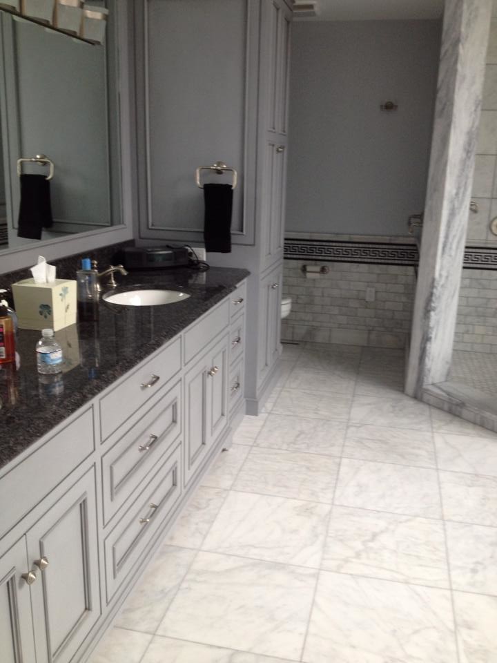 Example of a large beige tile corner shower design with a drop-in sink, gray cabinets and gray walls