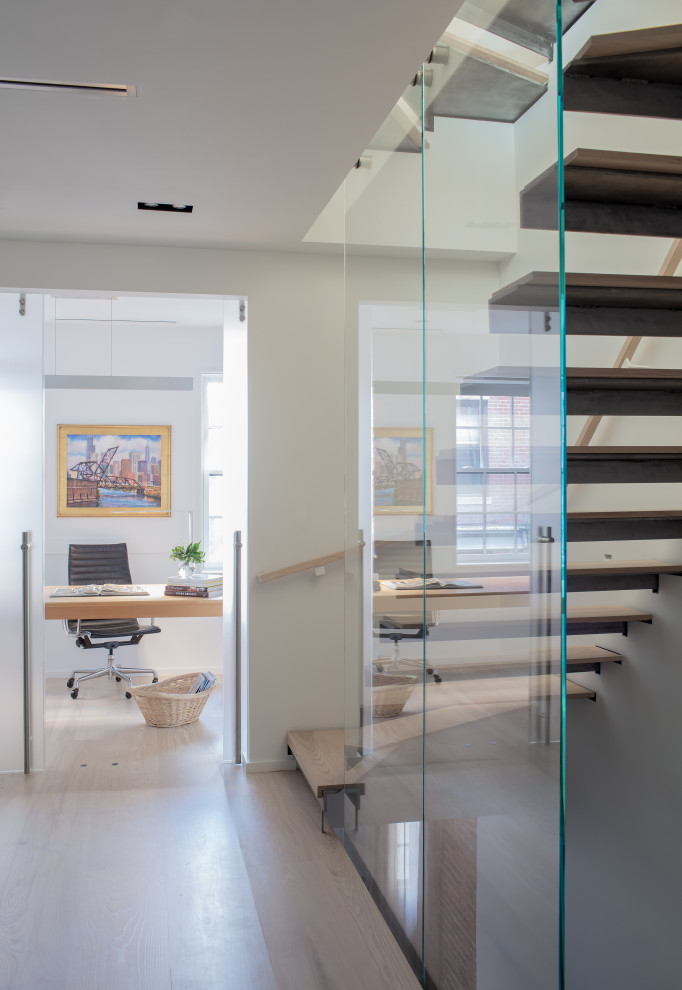 This is an example of a medium sized contemporary wood floating glass railing staircase in Boston with open risers.