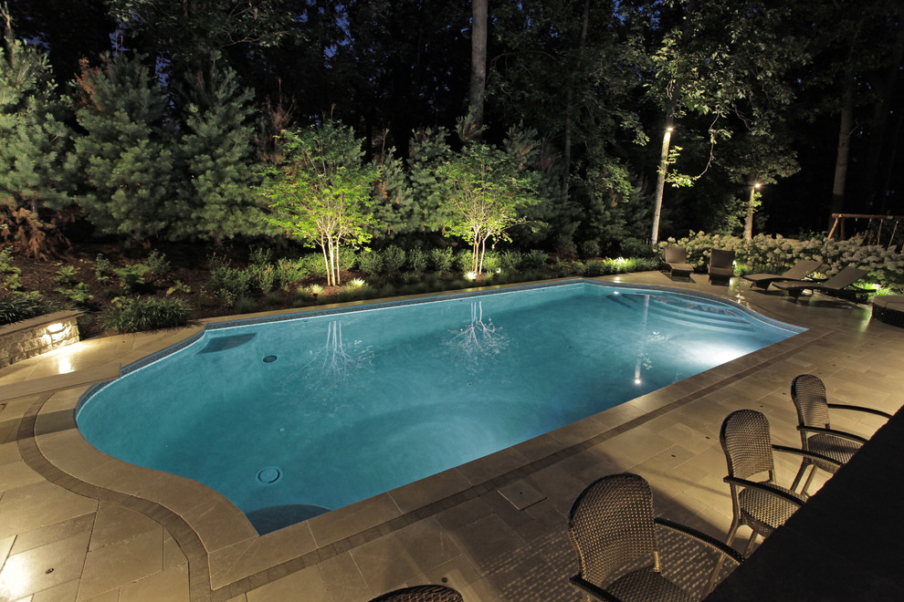 Huge transitional backyard tile and custom-shaped lap pool photo in New York