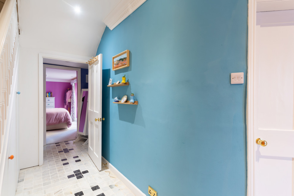 Diseño de recibidores y pasillos actuales de tamaño medio con paredes azules, suelo de baldosas de cerámica, suelo blanco y cuadros