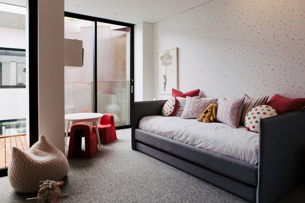 This is an example of an expansive contemporary kids' room for girls in Sydney with carpet and grey floor.