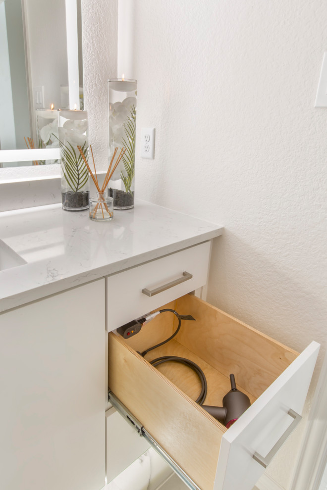 Example of a mid-sized minimalist gray tile and ceramic tile ceramic tile, white floor and single-sink bathroom design in Dallas with flat-panel cabinets, white cabinets, a two-piece toilet, gray walls, an undermount sink, quartzite countertops, white countertops and a built-in vanity