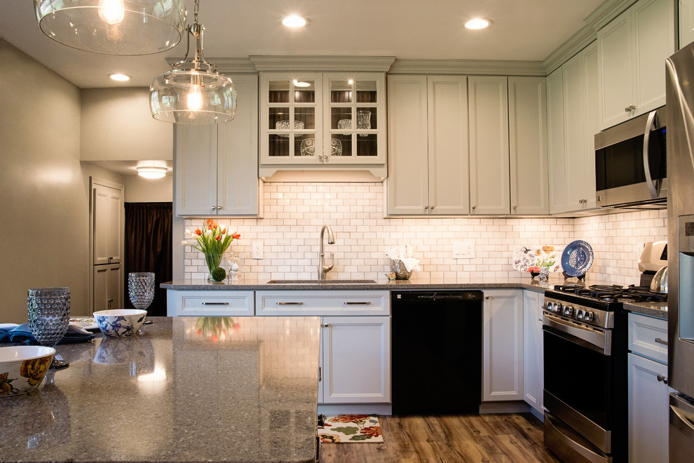 Eat-in kitchen - mid-sized transitional l-shaped vinyl floor eat-in kitchen idea with an undermount sink, recessed-panel cabinets, gray cabinets, quartz countertops, white backsplash, marble backsplash, stainless steel appliances and an island