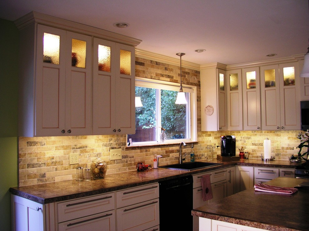 Open concept kitchen - large traditional l-shaped open concept kitchen idea in Phoenix with a drop-in sink, recessed-panel cabinets, beige cabinets, granite countertops, multicolored backsplash, subway tile backsplash, black appliances and an island