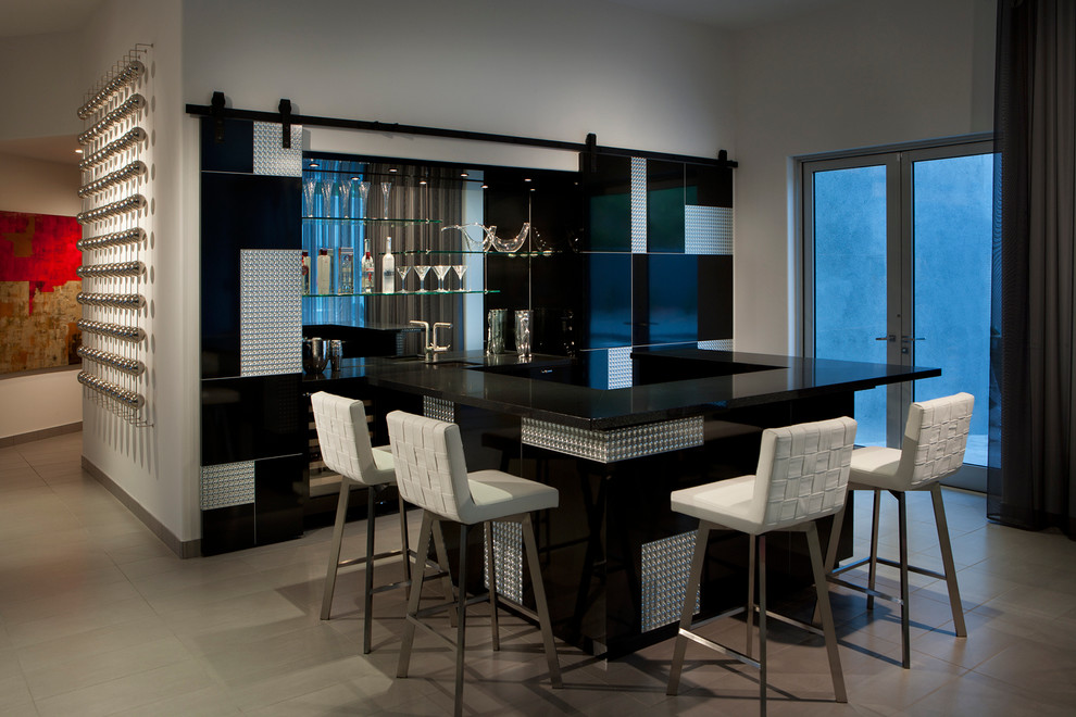 Inspiration for a contemporary u-shaped seated home bar in Phoenix with black cabinets, mirror splashback and beige floor.