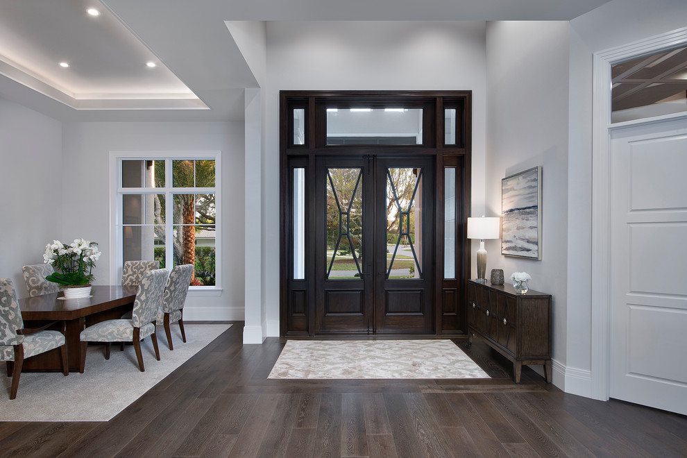 Example of a large transitional foyer design in Miami with a dark wood front door