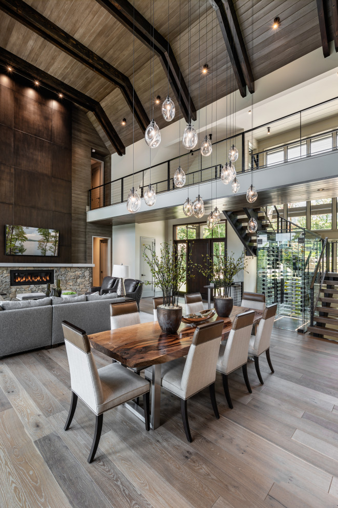 Inspiration for a country open plan dining in Other with white walls, medium hardwood floors, brown floor, vaulted and wood.