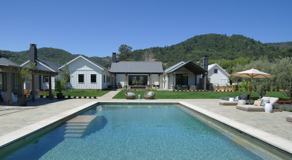 Country backyard pool in San Francisco with a pool house and natural stone pavers.