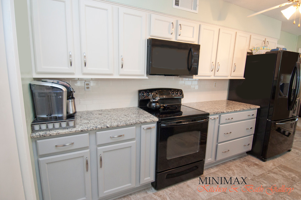 Example of a small transitional galley porcelain tile enclosed kitchen design with an undermount sink, shaker cabinets, gray cabinets, granite countertops, white backsplash, subway tile backsplash and black appliances