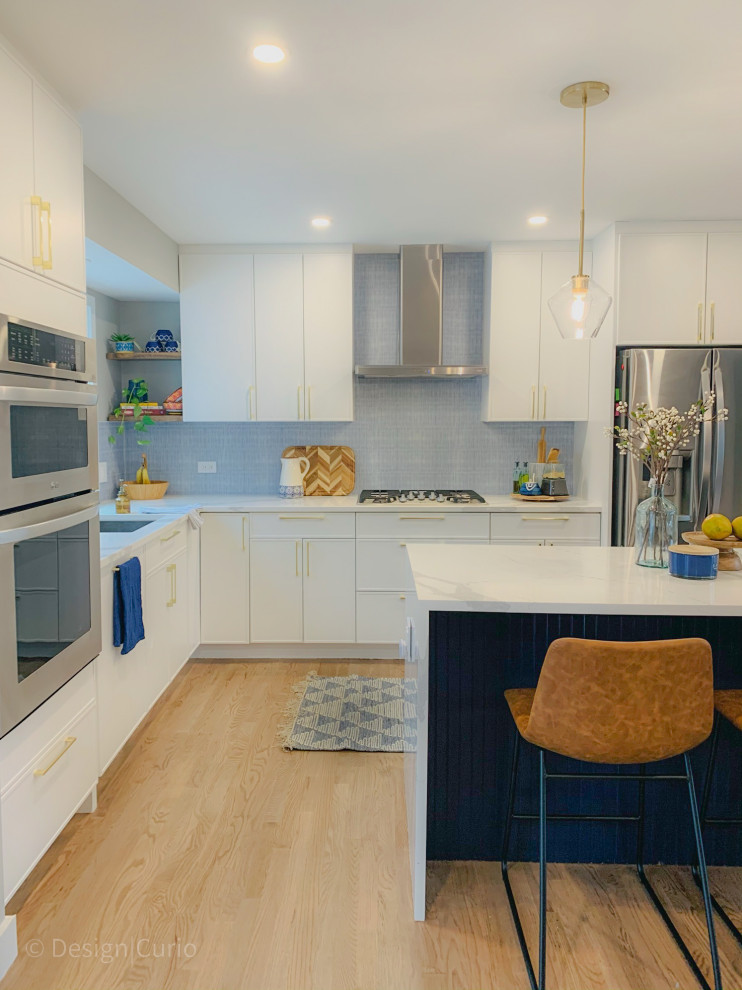 Esempio di una cucina moderna di medie dimensioni con lavello sottopiano, ante lisce, ante bianche, top in quarzite, paraspruzzi blu, paraspruzzi con piastrelle in ceramica, elettrodomestici in acciaio inossidabile, pavimento in legno massello medio, pavimento marrone e top bianco