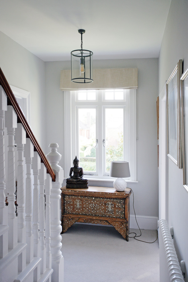 This is an example of a large eclectic hallway in Sussex with grey walls, carpet and grey floor.