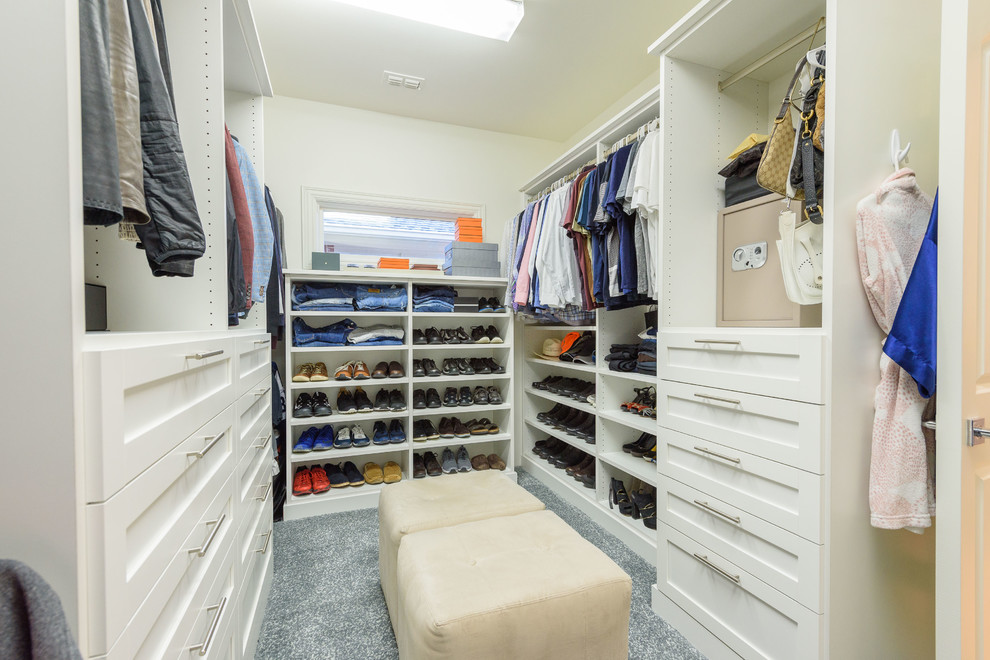 Photo of a mid-sized transitional gender-neutral dressing room in Dallas with raised-panel cabinets, white cabinets, carpet and grey floor.