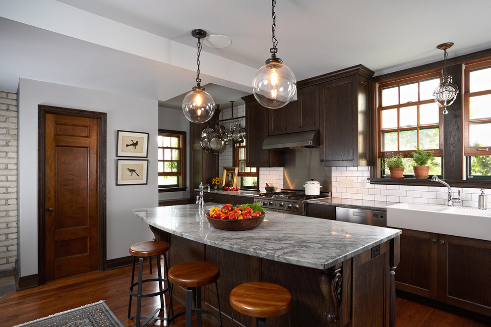 Photo of a traditional kitchen in Minneapolis with dark wood cabinets, white splashback and subway tile splashback.