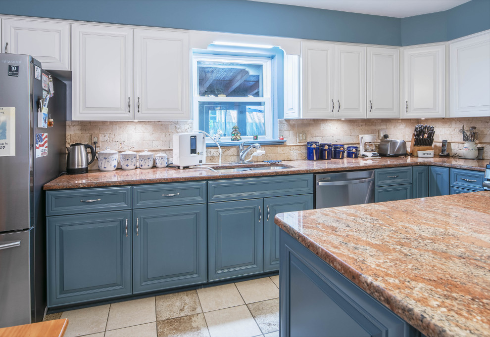 Photo of a mid-sized transitional l-shaped separate kitchen in Baltimore with an undermount sink, recessed-panel cabinets, blue cabinets, granite benchtops, beige splashback, stone tile splashback, stainless steel appliances, ceramic floors, with island, beige floor and orange benchtop.