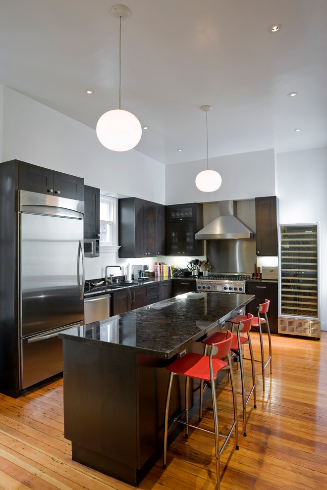 Small contemporary l-shaped separate kitchen in San Francisco with an undermount sink, dark wood cabinets, granite benchtops, black splashback, stainless steel appliances, medium hardwood floors and with island.