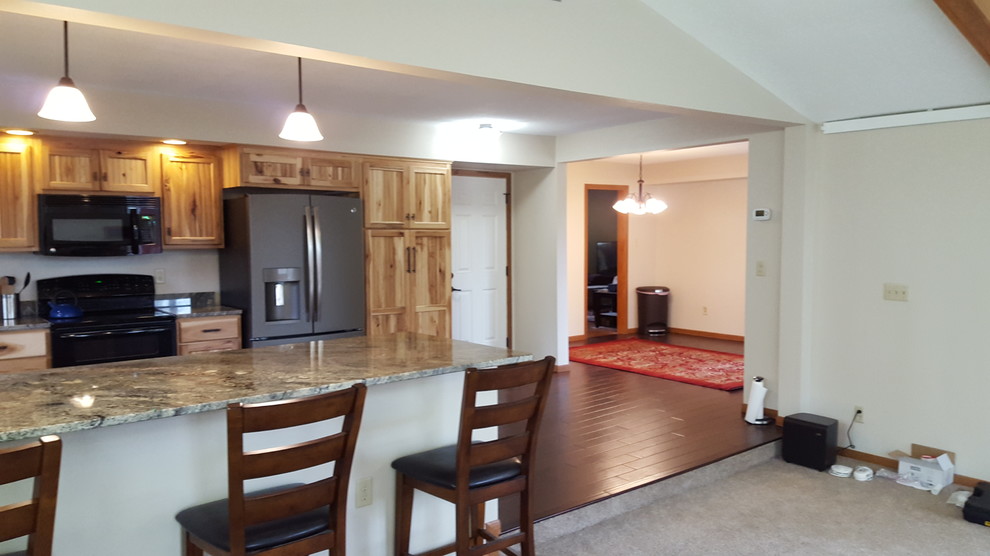U-shaped dark wood floor eat-in kitchen photo with an undermount sink, stainless steel appliances and a peninsula