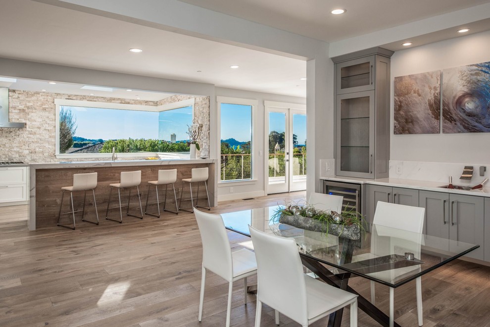 Example of a mid-sized transitional light wood floor great room design in Orange County with white walls and no fireplace