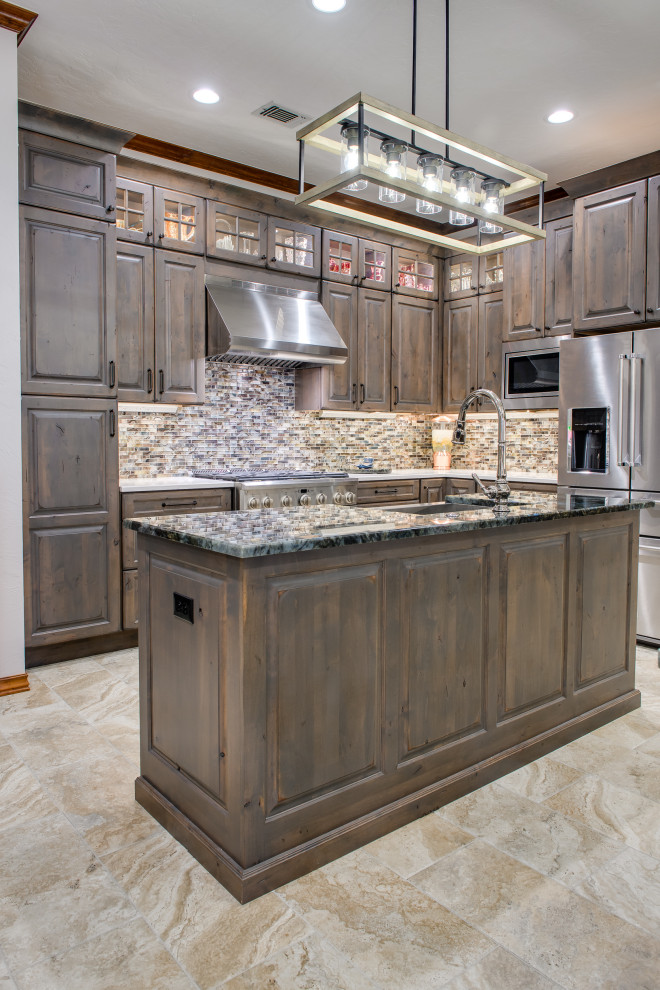 Large traditional l-shaped open plan kitchen in Oklahoma City with an undermount sink, raised-panel cabinets, grey cabinets, granite benchtops, multi-coloured splashback, stone tile splashback, white appliances, porcelain floors, multiple islands, beige floor and blue benchtop.
