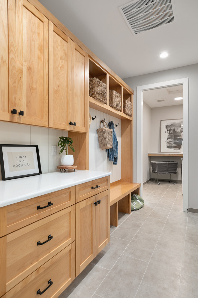 This is an example of a mid-sized modern galley utility room in Portland with a drop-in sink, shaker cabinets, brown cabinets, quartz benchtops, white splashback, white walls, porcelain floors, a concealed washer and dryer, grey floor and white benchtop.