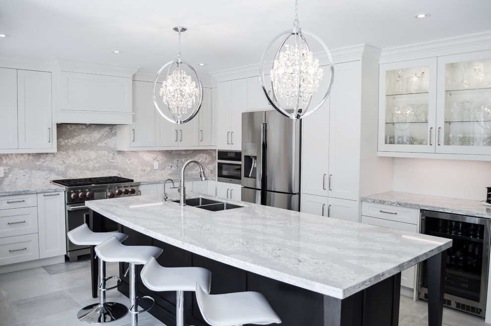 Inspiration for a large transitional l-shaped porcelain tile and gray floor enclosed kitchen remodel in Toronto with shaker cabinets, white cabinets, quartz countertops, stainless steel appliances, an island, a double-bowl sink and gray backsplash
