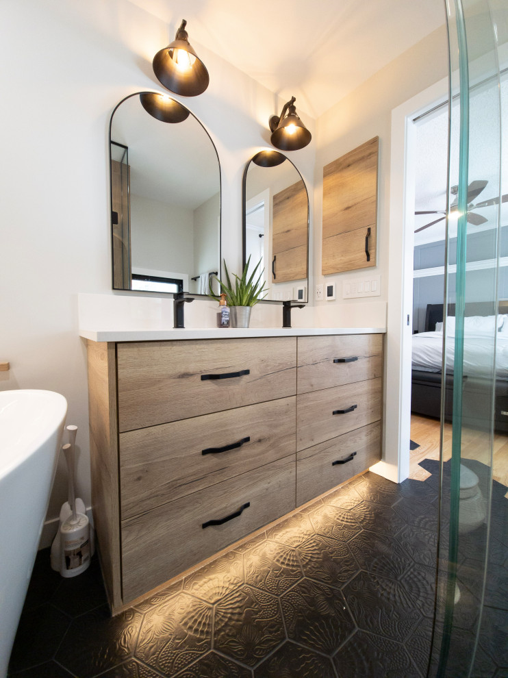 Inspiration for a mid-sized country master bathroom in Edmonton with flat-panel cabinets, medium wood cabinets, a freestanding tub, a curbless shower, white walls, porcelain floors, an undermount sink, engineered quartz benchtops, black floor, a hinged shower door, white benchtops, a shower seat, a double vanity and a built-in vanity.