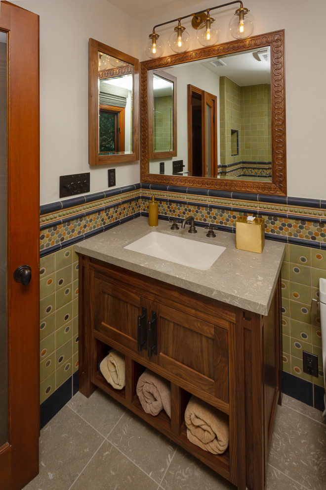 Идея дизайна: ванная комната в стиле кантри с фасадами в стиле шейкер, темными деревянными фасадами, ванной в нише, душем над ванной, разноцветной плиткой, керамической плиткой, разноцветными стенами, полом из известняка, душевой кабиной, врезной раковиной, столешницей из известняка, зеленым полом, душем с распашными дверями, зеленой столешницей, тумбой под одну раковину и напольной тумбой