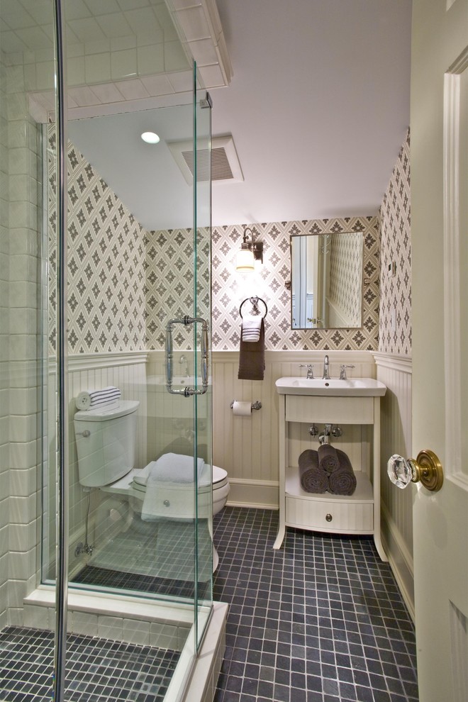 Inspiration for a traditional bathroom in New York with a wall-mount sink, white cabinets, a corner shower, a two-piece toilet, black tile and flat-panel cabinets.