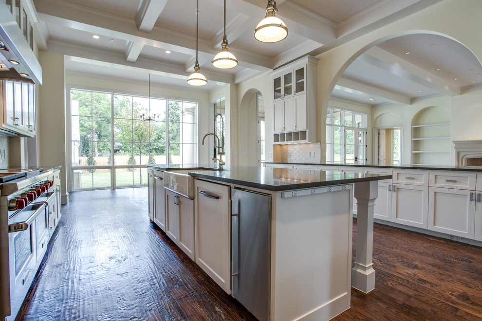 This is an example of a traditional eat-in kitchen in Dallas with a farmhouse sink, shaker cabinets, white cabinets and stainless steel appliances.