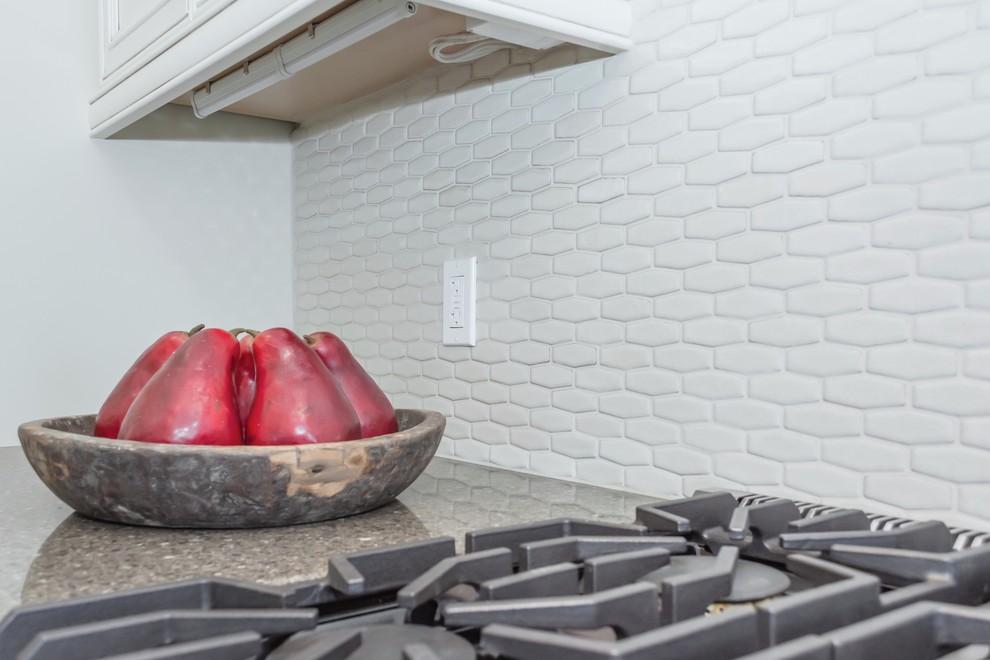Example of a large transitional master gray tile and ceramic tile porcelain tile freestanding bathtub design in Toronto with a farmhouse sink, white cabinets, quartz countertops, gray backsplash, ceramic backsplash, stainless steel appliances, an island, white walls and a vessel sink