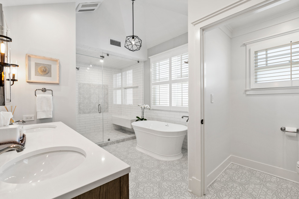 Large transitional master wet room bathroom in Los Angeles with furniture-like cabinets, distressed cabinets, a freestanding tub, white tile, subway tile, white walls, porcelain floors, multi-coloured floor and white benchtops.