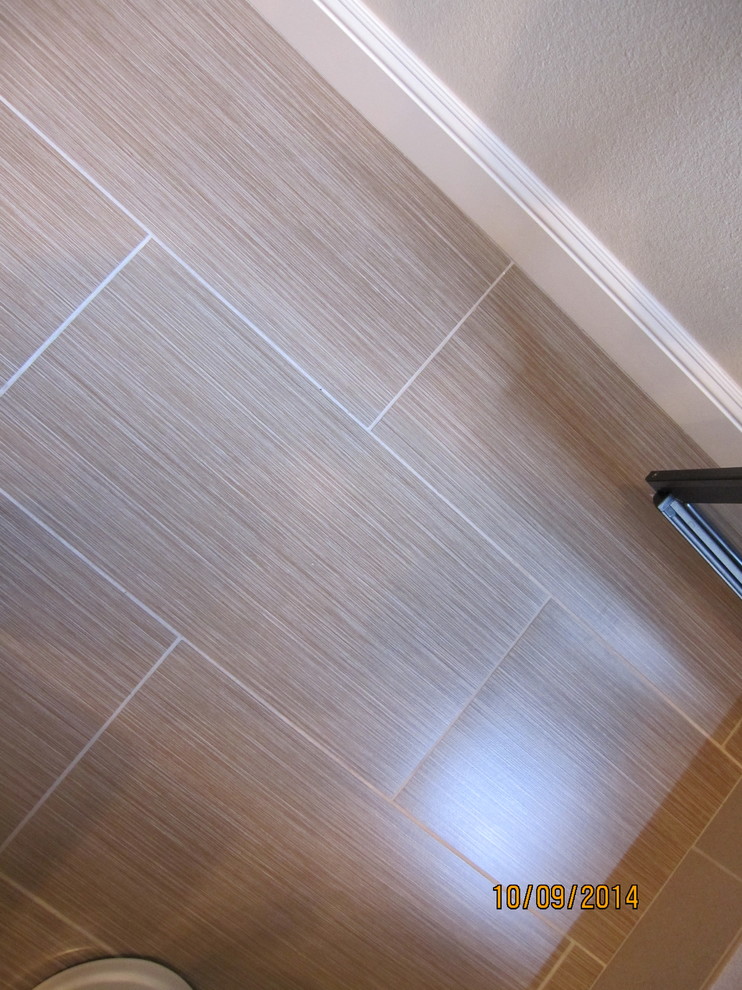 Mid-sized transitional 3/4 brown tile and porcelain tile porcelain tile home design photo with an undermount sink, raised-panel cabinets, white cabinets, granite countertops, a one-piece toilet and beige walls