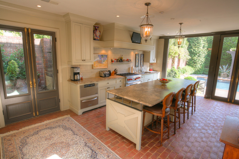 Example of a mid-sized classic l-shaped brick floor open concept kitchen design in Charlotte with an undermount sink, shaker cabinets, white cabinets, marble countertops, beige backsplash, subway tile backsplash, stainless steel appliances and an island