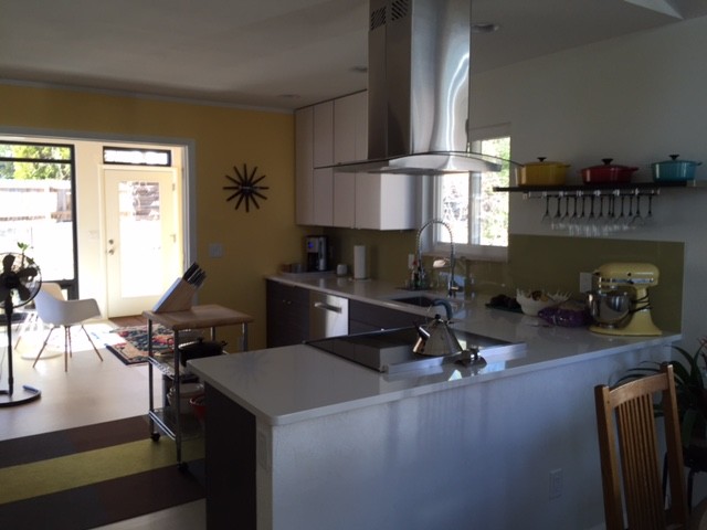 Inspiration for a mid-sized contemporary u-shaped ceramic tile and white floor eat-in kitchen remodel in Denver with an undermount sink, flat-panel cabinets, white cabinets, solid surface countertops, a peninsula and stainless steel appliances