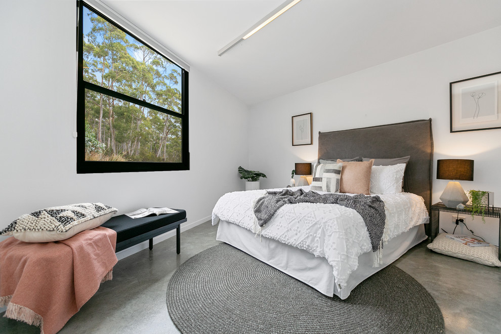 This is an example of a large contemporary master bedroom in Hobart with white walls, concrete floors and grey floor.