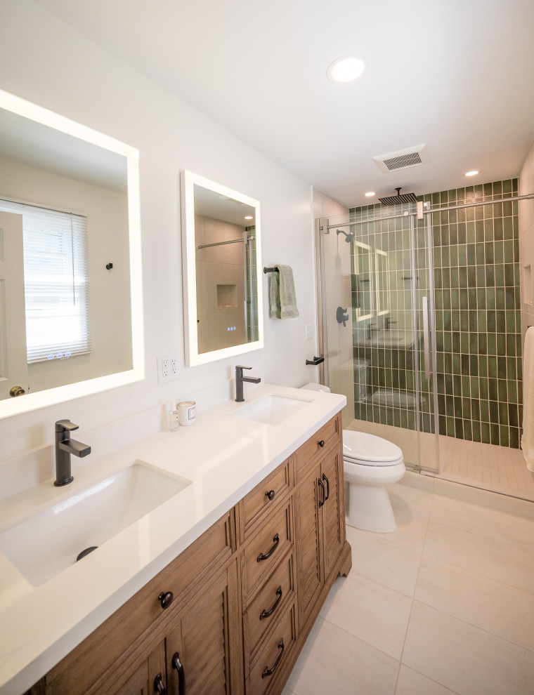 Mid-sized transitional 3/4 green tile and porcelain tile porcelain tile, beige floor and double-sink bathroom photo in Omaha with louvered cabinets, brown cabinets, a one-piece toilet, white walls, an undermount sink, quartz countertops, white countertops and a freestanding vanity