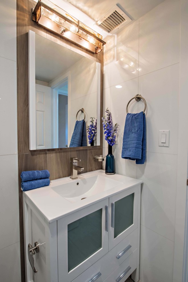 Mid-sized beach style master bathroom in Miami with furniture-like cabinets, dark wood cabinets, a one-piece toilet, white tile, porcelain tile, white walls, porcelain floors, solid surface benchtops, an alcove shower, an integrated sink, beige floor and a hinged shower door.