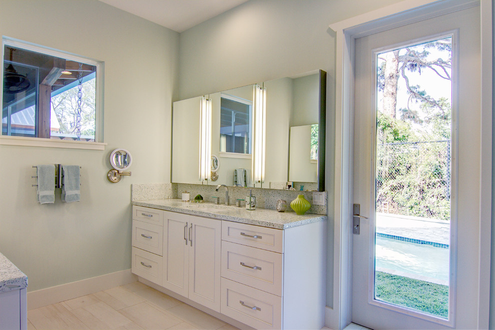 This is an example of a mid-sized contemporary master bathroom in Tampa with an undermount sink, recessed-panel cabinets, white cabinets, concrete benchtops, an open shower, a one-piece toilet, porcelain tile, green walls, porcelain floors and multi-coloured tile.