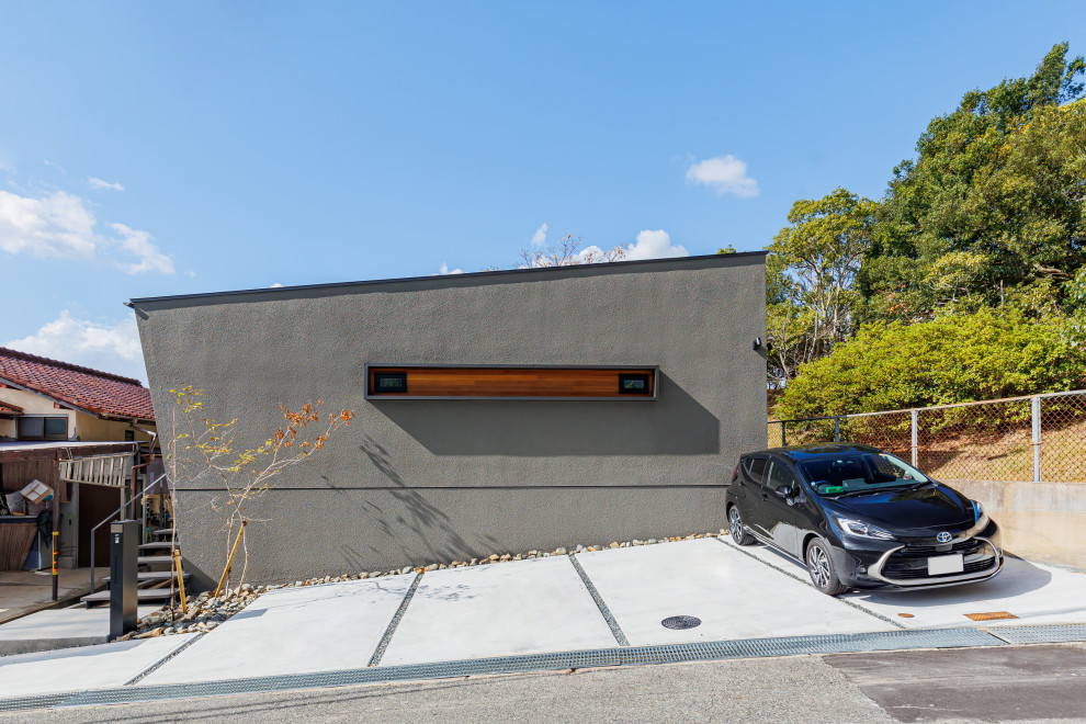 Photo of a medium sized and gey modern bungalow detached house in Kobe with a flat roof, a metal roof and a black roof.