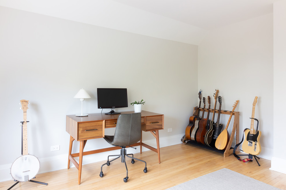 Photo of a scandinavian home studio in Boston with grey walls, light hardwood floors, a freestanding desk and beige floor.