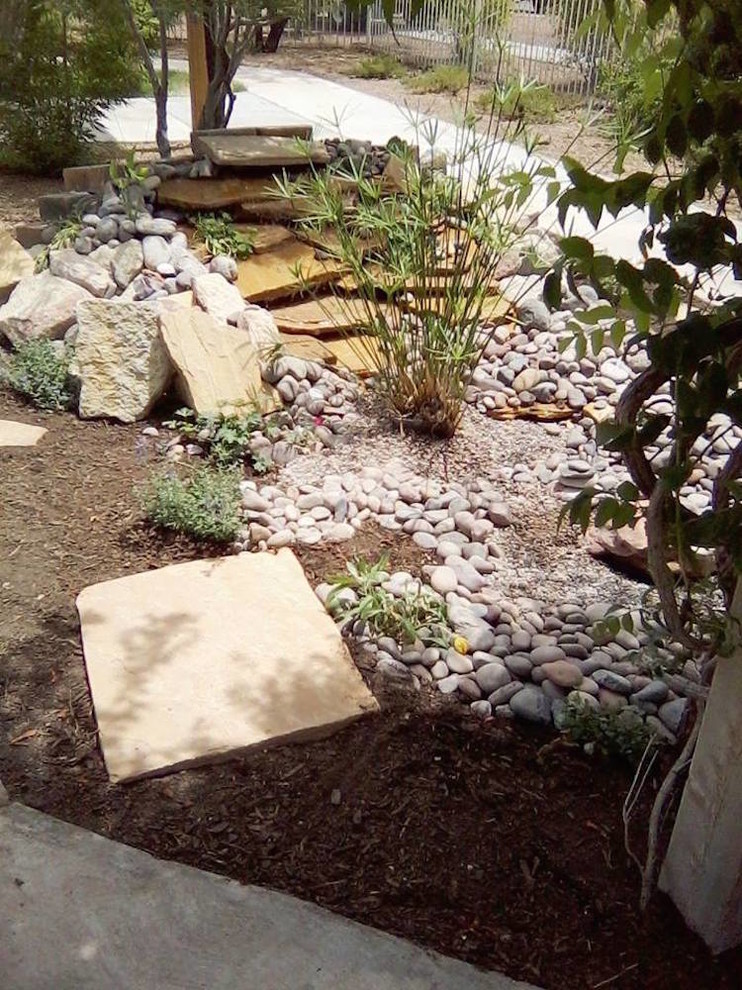 Design ideas for a large asian backyard partial sun xeriscape in Austin with with pond and mulch.
