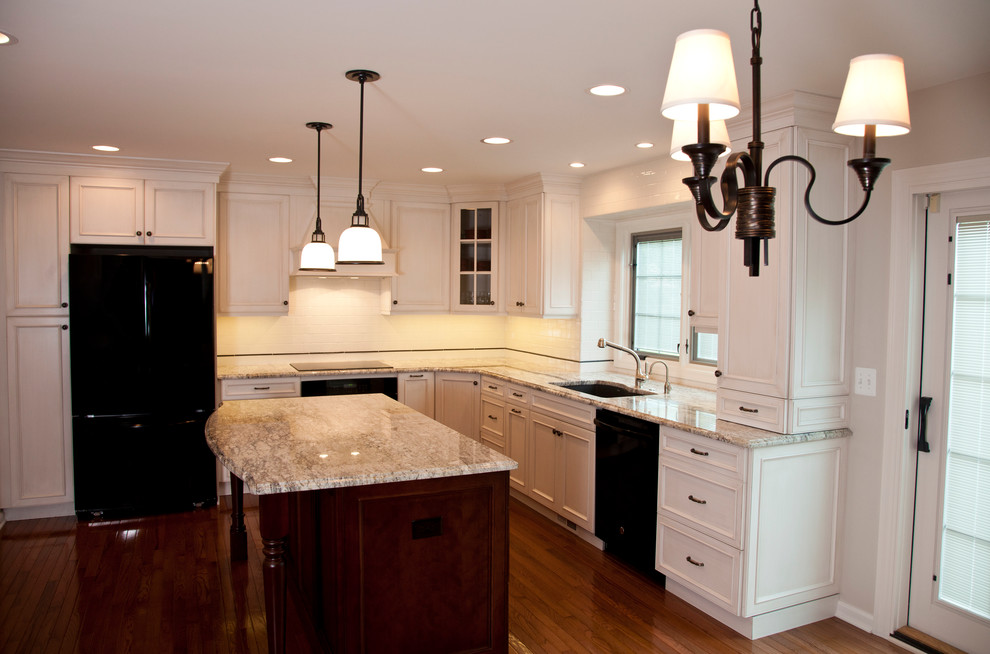 Eat-in kitchen - mid-sized transitional u-shaped medium tone wood floor eat-in kitchen idea in Detroit with an undermount sink, recessed-panel cabinets, white cabinets, granite countertops, white backsplash, ceramic backsplash, black appliances and an island