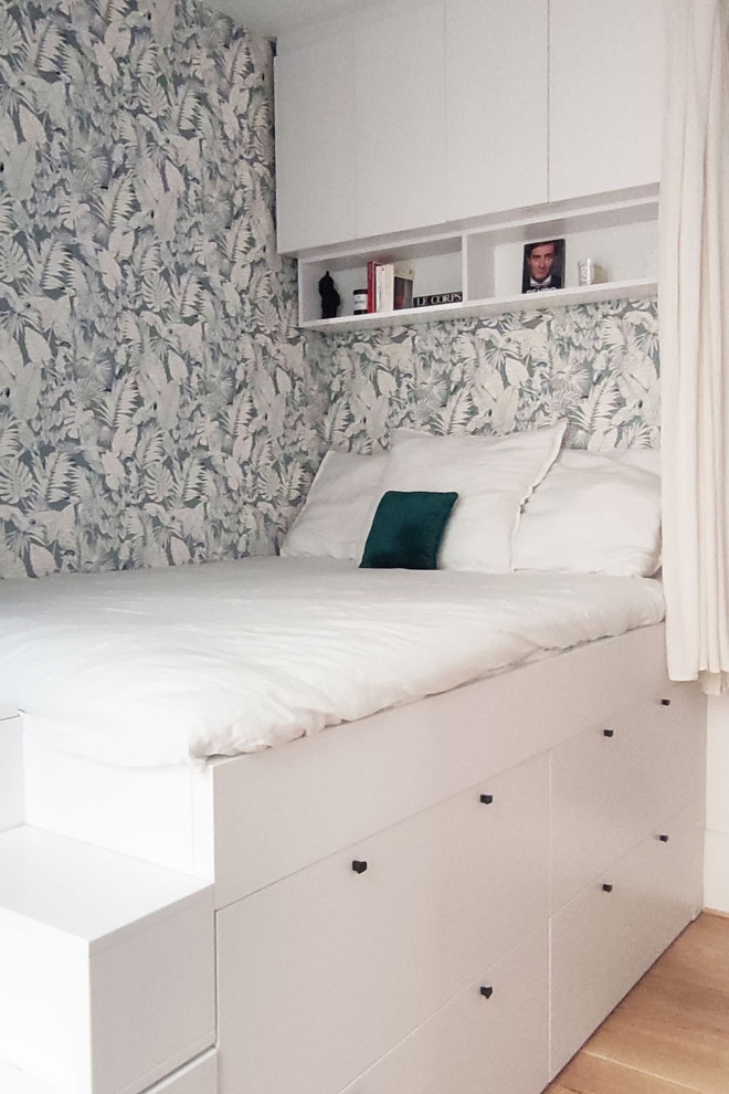 Esempio di una piccola camera da letto moderna con pareti beige, parquet chiaro e carta da parati