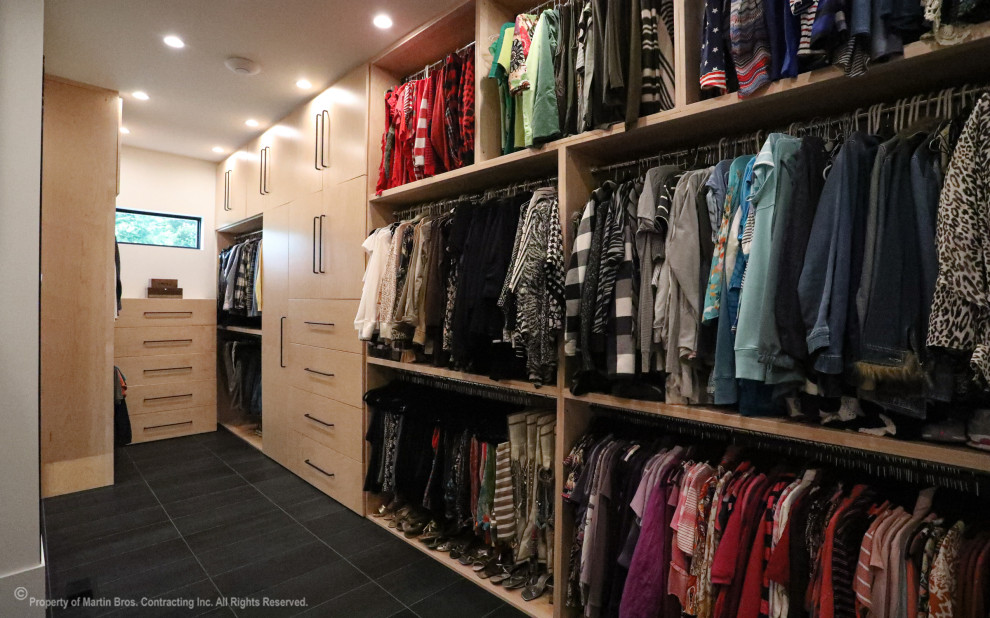 Ejemplo de armario vestidor unisex urbano extra grande con armarios con paneles lisos, puertas de armario de madera clara, suelo de baldosas de porcelana y suelo negro