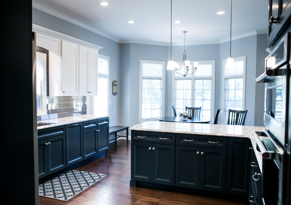 Design ideas for a large transitional kitchen in Indianapolis with an undermount sink, recessed-panel cabinets, blue cabinets, quartzite benchtops, blue splashback, porcelain splashback, stainless steel appliances, dark hardwood floors, a peninsula and brown floor.