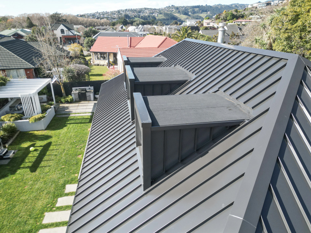 Idées déco pour une grande façade de maison blanche contemporaine en briques peintes de plain-pied avec un toit à quatre pans, un toit en métal et un toit noir.