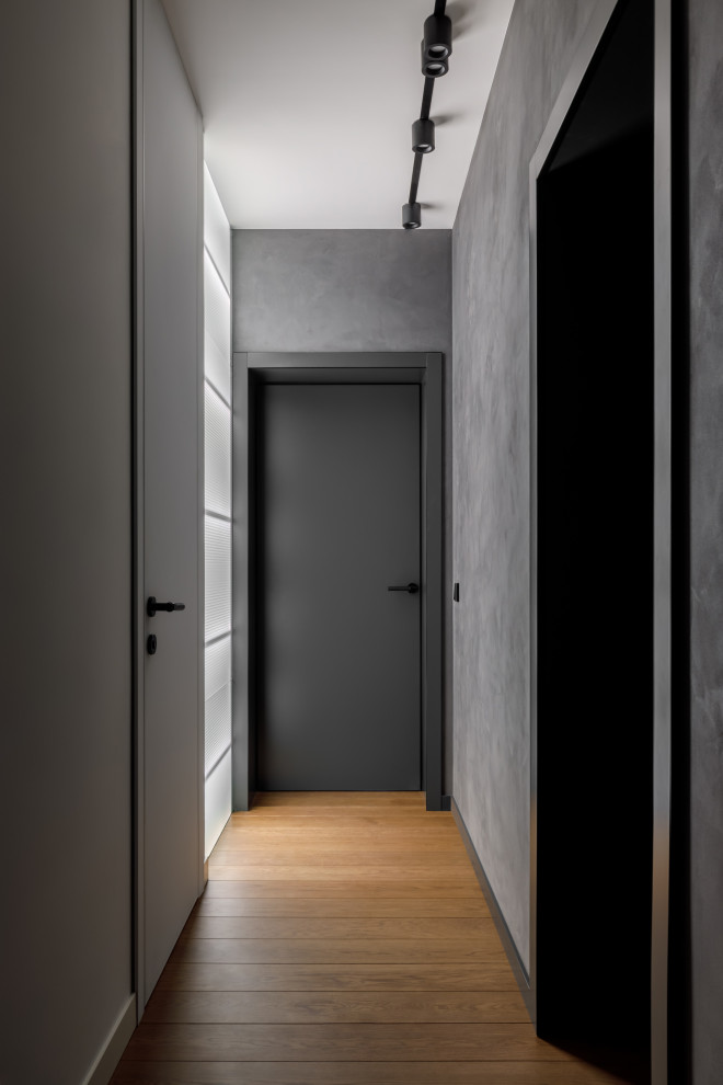 Cette photo montre un couloir tendance de taille moyenne avec un mur gris, parquet foncé, un sol marron, différents designs de plafond et du lambris.
