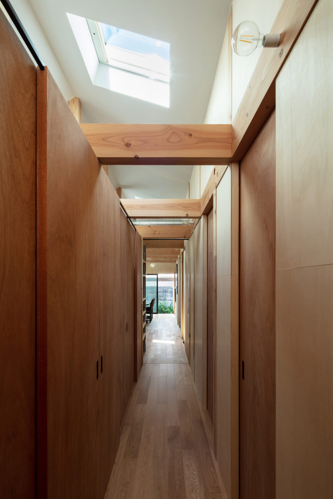 Esempio di una piccola cabina armadio unisex industriale con ante in legno bruno, parquet chiaro, pavimento marrone e soffitto ribassato