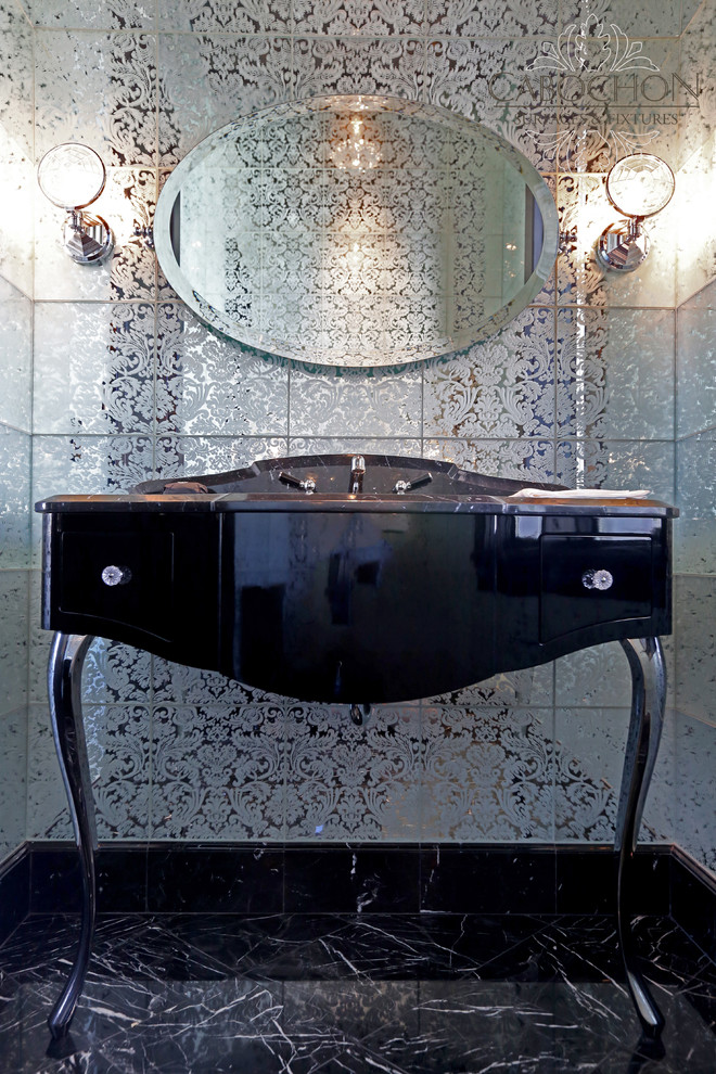 Photo of a mid-sized transitional powder room in San Diego with a console sink, furniture-like cabinets, black cabinets, marble benchtops, a two-piece toilet, black tile, mirror tile, white walls and marble floors.
