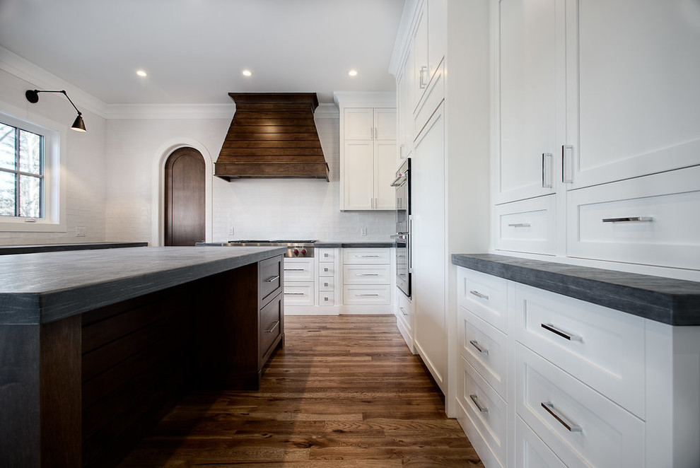 Example of a large transitional u-shaped eat-in kitchen design in Calgary with shaker cabinets, paneled appliances and an island